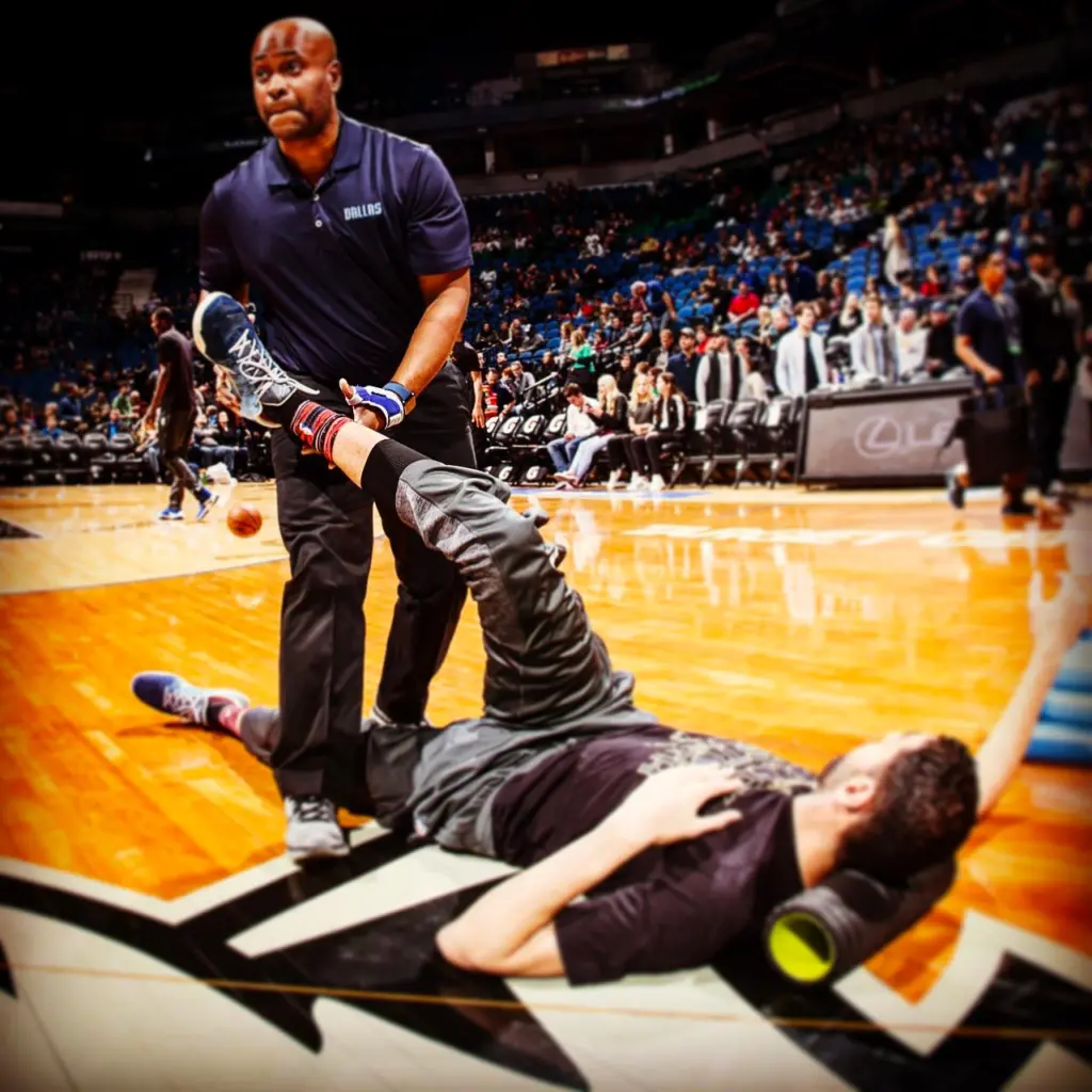 Nba trainer helping player stretch